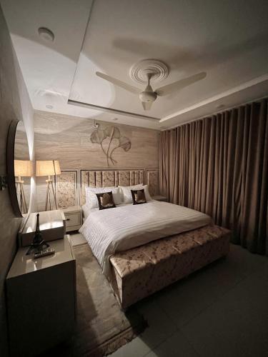 a bedroom with a large bed and a table at Kings Den 1BHK in Rawalpindi
