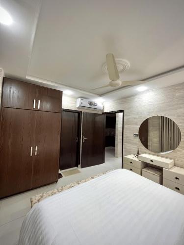a bedroom with a large bed and a mirror at Kings Den 1BHK in Rawalpindi