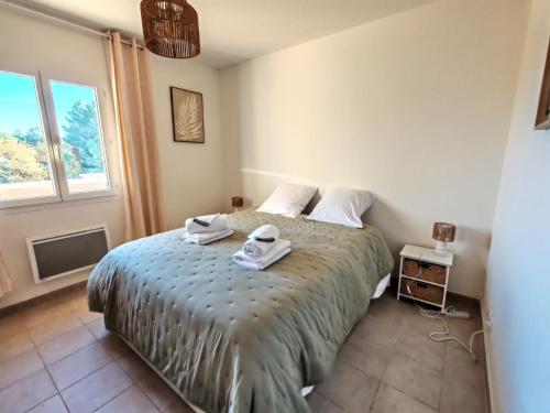 une chambre avec un lit avec des serviettes dessus dans l'établissement Les deux Oliviers, à Roussillon