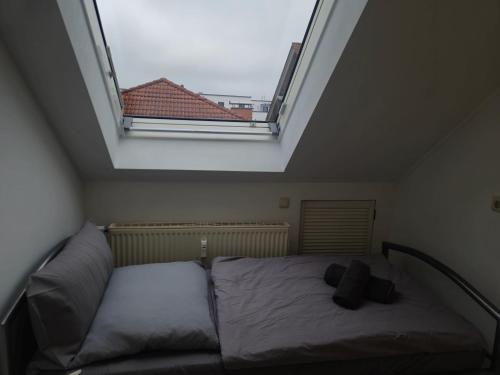 a bed in a room with a large window at Parkplätze, Einzelbetten, 2 Balkone, fast Wi-Fi 100 Mbit, Homeoffice, Aufzug, lichtdurchflutet, Panoramablick in Erlensee