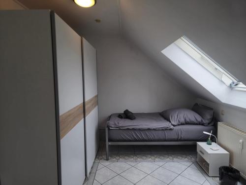 a small room with a bed in the attic at Parkplätze, Einzelbetten, 2 Balkone, fast Wi-Fi 100 Mbit, Homeoffice, Aufzug, lichtdurchflutet, Panoramablick in Erlensee