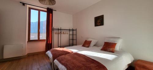 une chambre avec deux lits et une fenêtre dans l'établissement Gite Le Banc du Peyron au Champ des Cimes, à Aubessagne