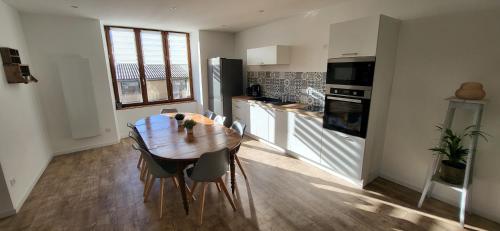 une cuisine avec une table en bois et une salle à manger dans l'établissement Gite Le Banc du Peyron au Champ des Cimes, à Aubessagne