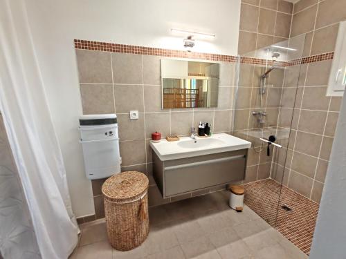 une salle de bain avec un lavabo et une douche dans l'établissement Les deux Oliviers, à Roussillon