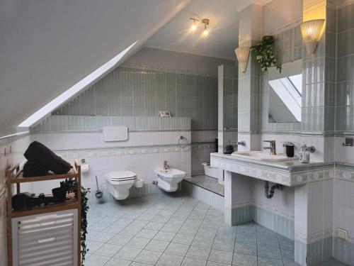 a bathroom with a sink and a toilet and a sink at Parkplätze, Einzelbetten, 2 Balkone, fast Wi-Fi 100 Mbit, Homeoffice, Aufzug, lichtdurchflutet, Panoramablick in Erlensee