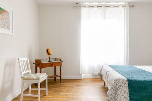 a bedroom with a bed and a chair and a desk at La Boulangerie Appartement 1 in Janzé