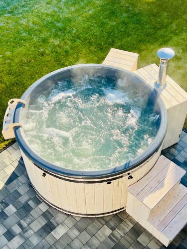 a large hot tub sitting on a table in a yard at Wyskocz w góry - domek z balią ogrodową in Szczyrk
