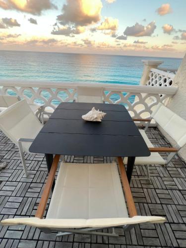 a table and chairs on a balcony overlooking the ocean at “Magic Sunrise at Cancun” in Cancún