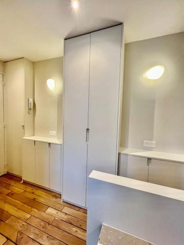 Cette chambre dispose de parquet et d'une grande armoire blanche. dans l'établissement Appartement Paris 15 Porte de Versailles, à Paris