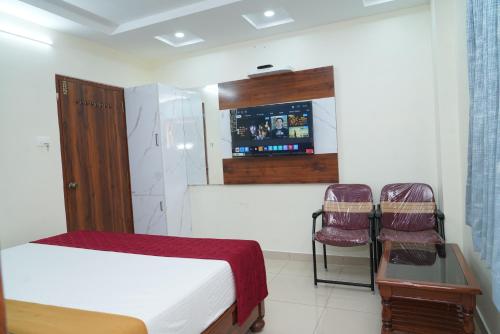 Una televisión o centro de entretenimiento en HOTEL THANVi INN