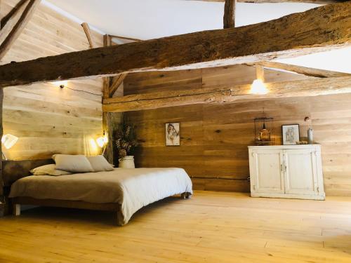 - une chambre avec un lit et des murs en bois dans l'établissement Maison drôles d'oiseaux, à Plieux
