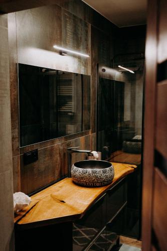 a bathroom with a sink on a wooden counter at Apartament Madlen Art in Olecko