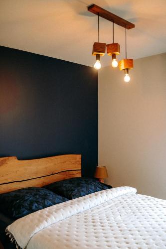 a bedroom with a white bed and a black wall at Apartament Madlen Art in Olecko