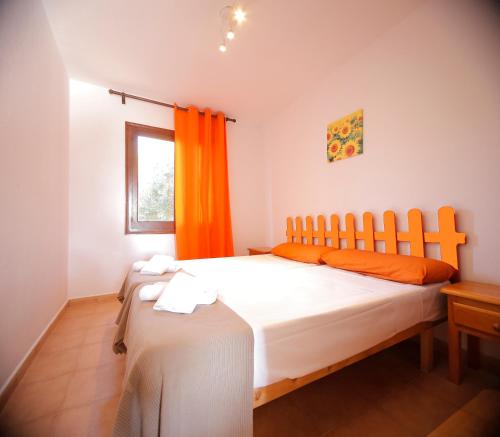 1 dormitorio con 1 cama grande y cortina de color naranja en Binibeca Mar II en Binibeca