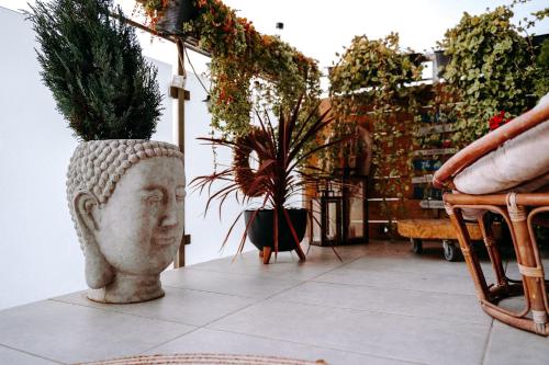 a statue of a head sitting on a floor with plants at Apartament Madlen Art in Olecko