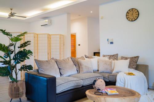 a living room with a couch and a table at Kira Japandi Escape with Sauna & Rooftop cinema in Hua Hin