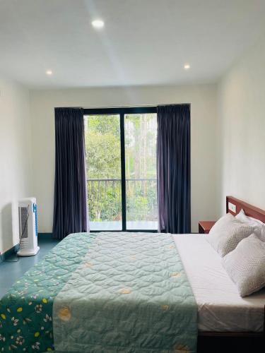 a bedroom with a large bed and a large window at Senthamarai villa in Sultan Bathery