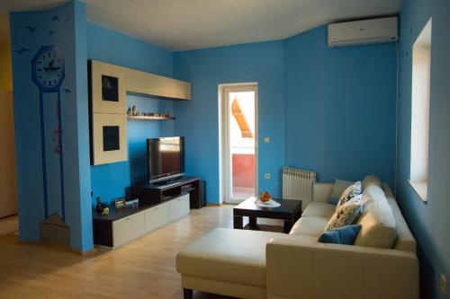Sala de estar azul con sofá y TV en Apartment Giro, en Zagreb