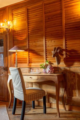 un bureau en bois avec une chaise et une lampe dans l'établissement A l'Ombre du Château, à Nans-sous-Sainte-Anne