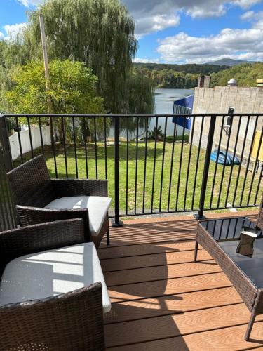 a deck with chairs and tables and a view of a river at Saugerties Waterfront Getaway in Saugerties