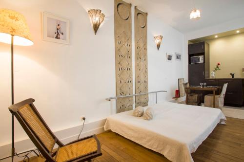 a bedroom with a bed and a chair and a table at Studio Beaune in Paris