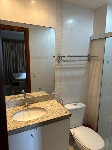 a bathroom with a sink and a toilet and a mirror at Flats - Veredas do Rio Quente in Rio Quente