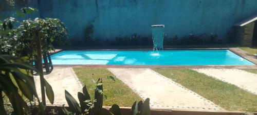 a swimming pool with a fountain in a yard at Casa analia in Porto Seguro