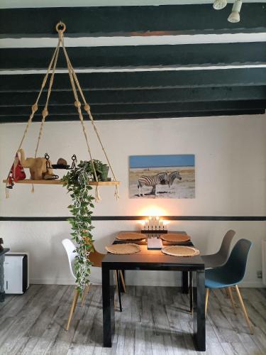 une salle à manger avec une table et un zèbre sur le mur dans l'établissement Penty atypique ,calme et à deux pas du centre, à Châteaulin