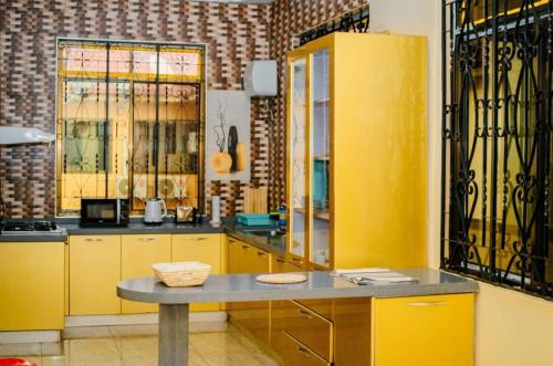 een keuken met gele kasten en een tafel bij Cozy home in Morogoro in Morogoro