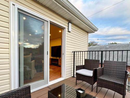 a balcony with two chairs and a sliding glass door at Saugerties Waterfront Getaway in Saugerties