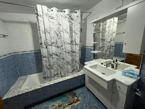 a bathroom with a shower curtain and a sink at Casa de Lino in Laxe