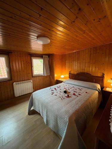 a bedroom with a bed with rose petals on it at Casa de Lino in Laxe