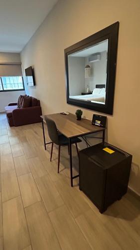 a living room with a table and a mirror at Suites Athos4 in Cancún