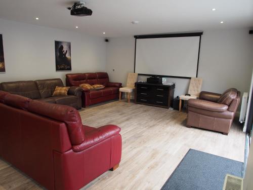 a living room with leather furniture and a white screen at Family and dog friendly stunning barn conversion in Tarbolton