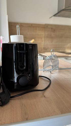 un grille-pain noir assis au-dessus d'une table dans l'établissement Gîte La Grange de Pardies, à Orthevielle