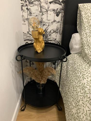 - une table noire à côté d'un lit avec une lampe dans l'établissement le studio d'alex, à Arras