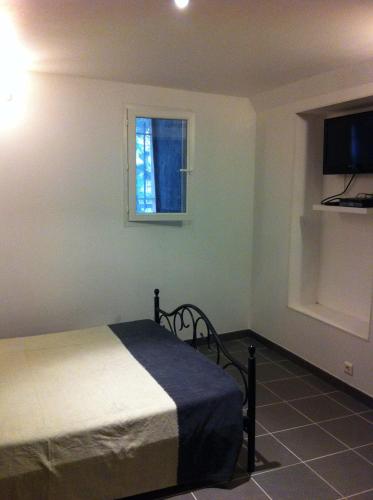 une chambre avec un lit et une fenêtre dans l'établissement Appartement centre ville, à Ajaccio