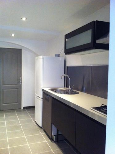 une cuisine avec un réfrigérateur blanc et un évier dans l'établissement Appartement centre ville, à Ajaccio