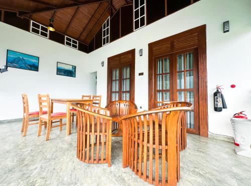 a dining room with wooden chairs and a table at Mount Seven Holiday Inn in Belihul Oya