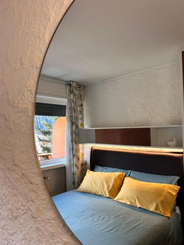 a mirror reflection of a bed in a bedroom at Central recently renovated apartment - Casa Tre Pini in Madonna di Campiglio