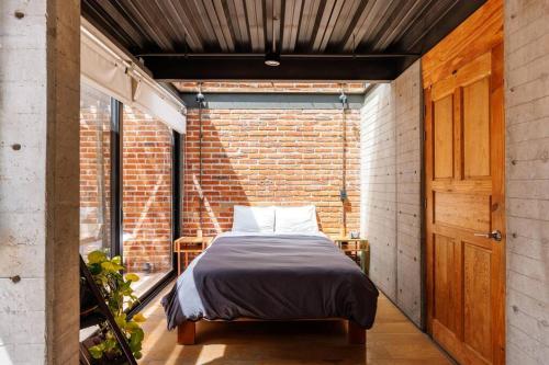 a bedroom with a bed in a brick wall at Casa Franco - Modern Architecture Home with AC in San Miguel de Allende