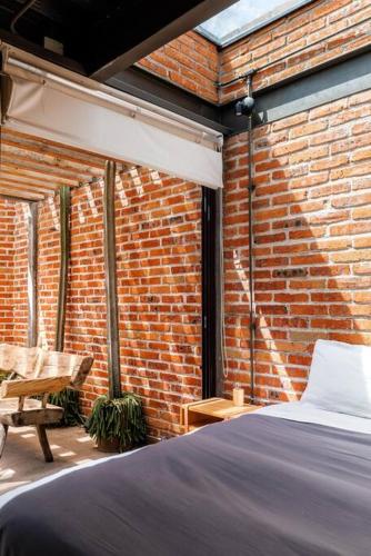 a bedroom with a bed and a brick wall at Casa Franco - Modern Architecture Home with AC in San Miguel de Allende