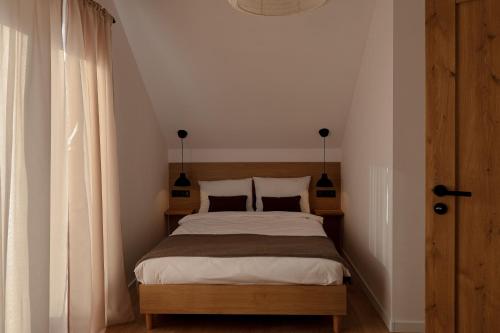 a bedroom with a bed with two pillows at Leśne Chatki - domek Jodła in Koniaków