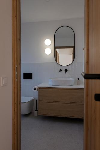a bathroom with a sink and a mirror and a tub at Leśne Chatki - domek Jodła in Koniaków
