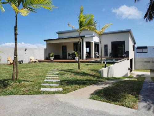 una casa con delle palme davanti di Villa d'Eden a Saint-Joseph