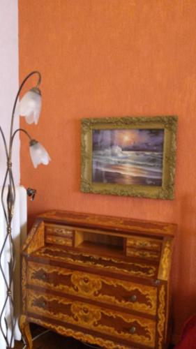 a dresser in a room with a painting on the wall at B&B Amarantha Gothica Genoa in Genova