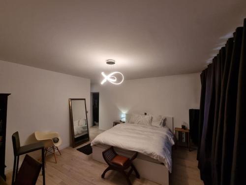 une chambre avec un grand lit et un ventilateur de plafond dans l'établissement Appart 6 pers joinville Bois de Vincennes, à Joinville-le-Pont