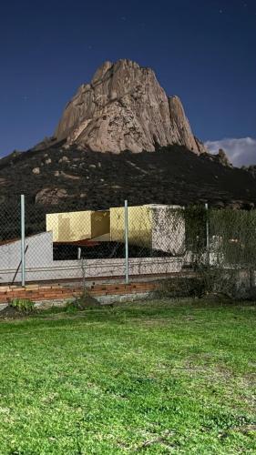 a mountain in the background with a fence and grass at Hotel Quinta Mirador Zacualli in Bernal