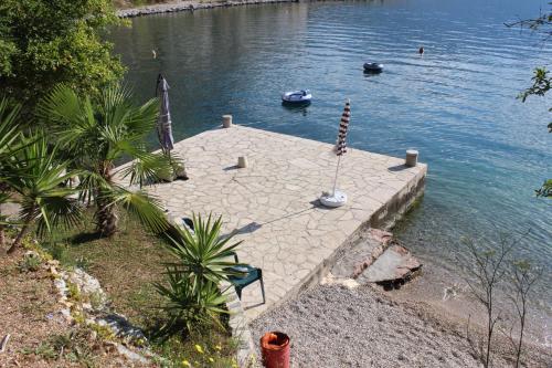 a dock with boats in a body of water at Apartments Mijuskovic in Donji Morinj