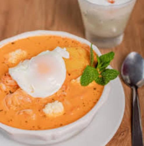 a bowl of soup on a table with a spoon at CHEZ NOUS in Carrillo